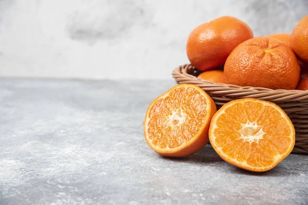 Taştan arka planda sulu portakal meyveleriyle dolu bir hasır kutu. Yüksek kalite fotoğraf