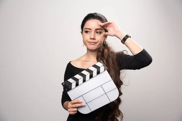Uma Garota Cineasta Segurando Uma Tábua Aberta Parecendo Confusa Pensando — Fotografia de Stock