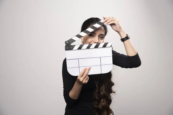一个电影制作女孩拿着一块敞着的拍板从里面看过去 高质量的照片 — 图库照片