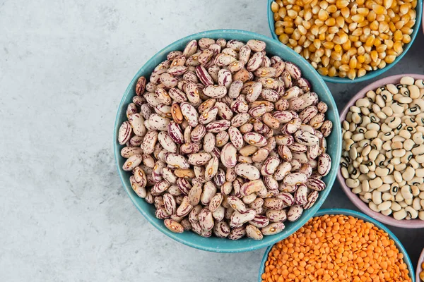 Bir sürü pişmemiş fasulye, mısır ve mermer yüzeyde kırmızı mercimek. Yüksek kalite fotoğraf