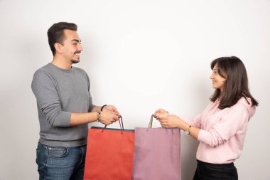 Beyaz arka planda alışveriş torbaları tutan mutlu çift. Yüksek kalite fotoğraf