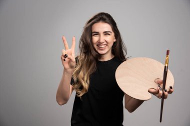 Boş palet ve fırçayla gülen ve tabela yapan kadın ressam. Yüksek kalite fotoğraf