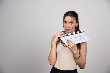 Gri arka planda alkışlarla poz veren güzel bir kadın. Yüksek kalite fotoğraf