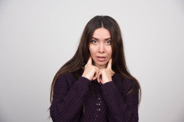 Ayakta duran ve poz veren kalın kazaklı çekici bir kadın. Yüksek kalite fotoğraf