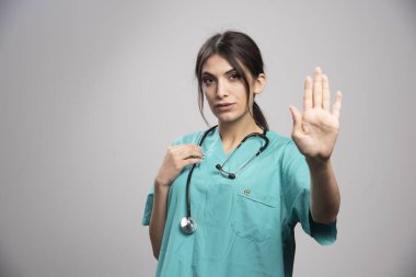 Gri arka planda poz veren kadın doktor. Yüksek kalite fotoğraf