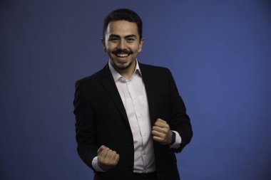 Siyah takım elbiseli bir iş adamı şans işareti yapar. Yüksek kalite fotoğraf