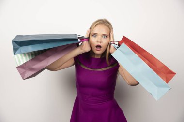 Kulaklarını renkli alışveriş torbalarıyla kaplayan bir kadın alışverişi. Yüksek kalite fotoğraf