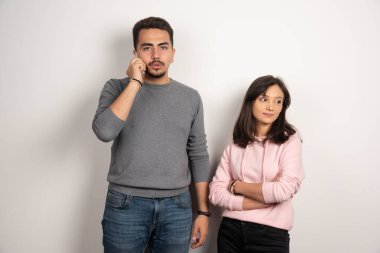 Kadın ayakta dururken adam telefonla konuşuyor. Yüksek kalite fotoğraf