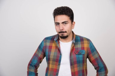 Üzgün genç sakallı adam ellerini kalçasına koyuyor. Yüksek kalite fotoğraf