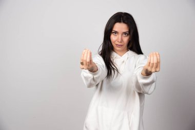 Beyaz arka planda duran ve poz veren güzel bir genç kadının portresi. Yüksek kalite fotoğraf