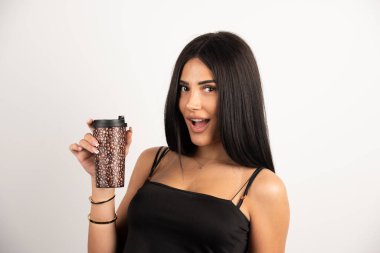 Siyah bluzlu kadın elinde mutlu bir ifadeyle bir fincan kahve tutuyor. Yüksek kalite fotoğraf