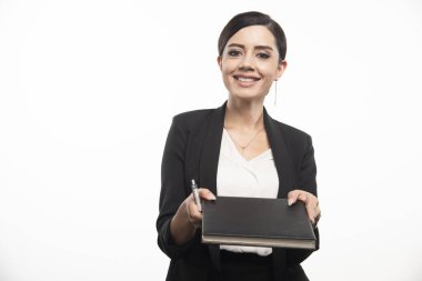 Genç bir çalışan beyaz arka planda not defteri veriyor. Yüksek kalite fotoğraf