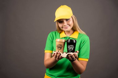 Dağıtıcı kadın arka planda bir fincan kahve ikram ediyor. Yüksek kalite fotoğraf