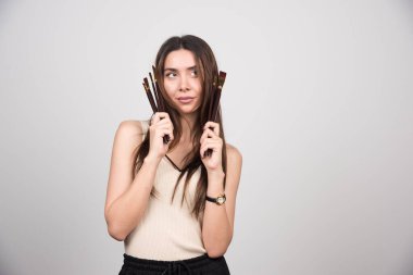 Gri arka planda fırçalarla poz veren kadın ressam. Yüksek kalite fotoğraf