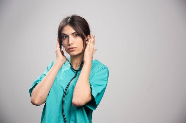 Steteskoplu kadın doktor gri arka planda duruyor. Yüksek kalite fotoğraf