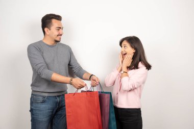 Beyaz arka planda alışveriş torbaları taşıyan tatlı bir çift. Yüksek kalite fotoğraf