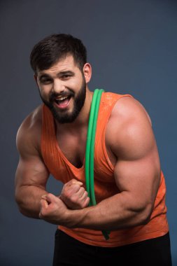 Koyu mavi arka planda spor olsun diye lastik tutan olumlu bir adam. Yüksek kalite fotoğraf