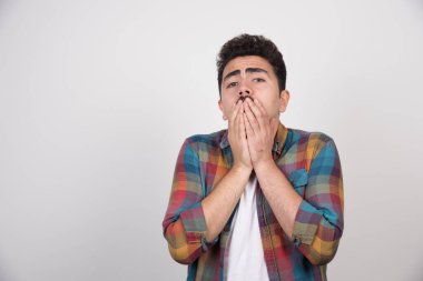 Elini ağzına dayayan ürkek bir adam. Yüksek kalite fotoğraf