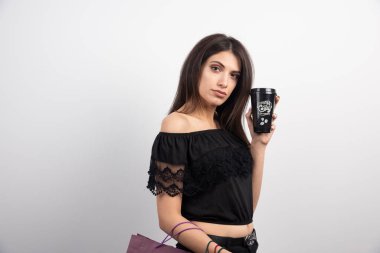 Esmer kadın beyaz arka planda kahve fincanı gösteriyor. Yüksek kalite fotoğraf