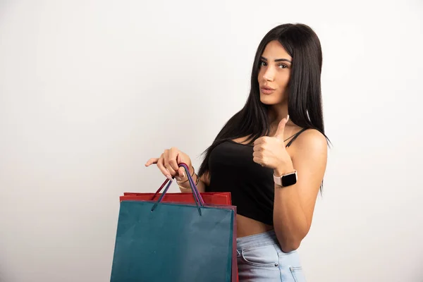 Morena Mulher Segurando Sacos Compras Fazendo Polegares Para Cima Sinal — Fotografia de Stock