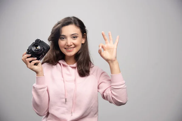 Kobieta Fotograf Trzyma Kamerę Robi Znak Wysokiej Jakości Zdjęcie — Zdjęcie stockowe