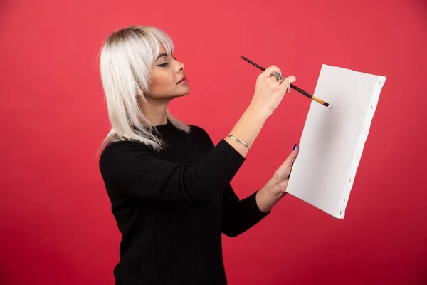 Junge Künstlerin Zeichnet Auf Leinwand Auf Rotem Hintergrund Hochwertiges Foto — Stockfoto