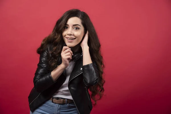 Mujer Joven Escuchando Música Auriculares Posando Sobre Fondo Rojo Foto — Foto de Stock