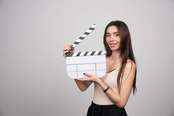 Wanita Berambut Cokelat Muda Dengan Clapperboard Berdiri Atas Latar Belakang — Stok Foto