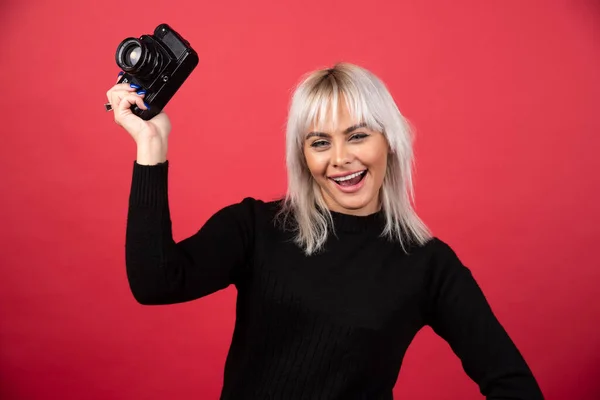 Mooie Jonge Vrouw Met Een Camera Terwijl Tegen Een Rode — Stockfoto