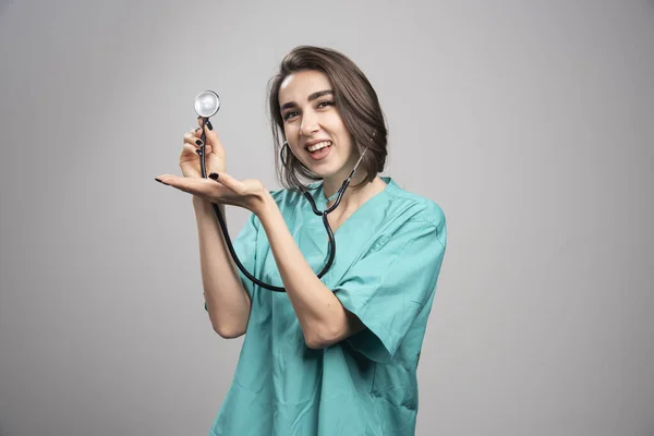 灰色の背景に聴診器を示す幸せな医者 高品質の写真 — ストック写真