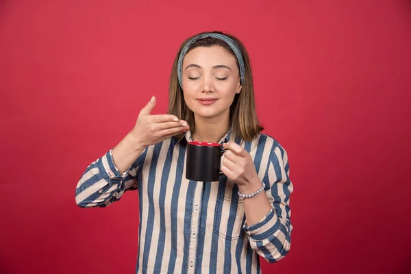 Glada Kvinna Luktar Doft Kaffe Röd Bakgrund Högkvalitativt Foto — Stockfoto