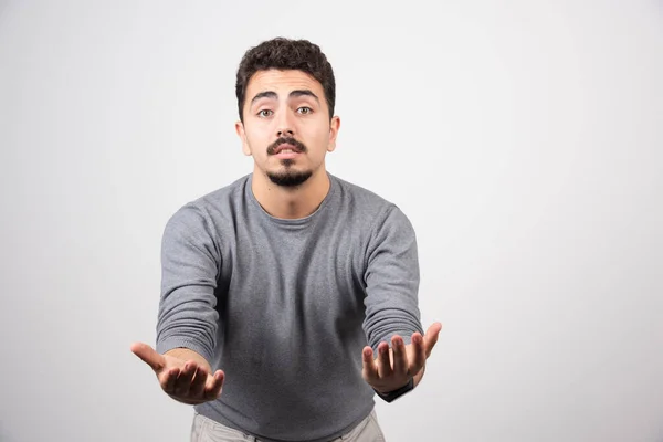 Een Jongeman Die Poseert Met Zijn Handen Een Witte Muur — Stockfoto