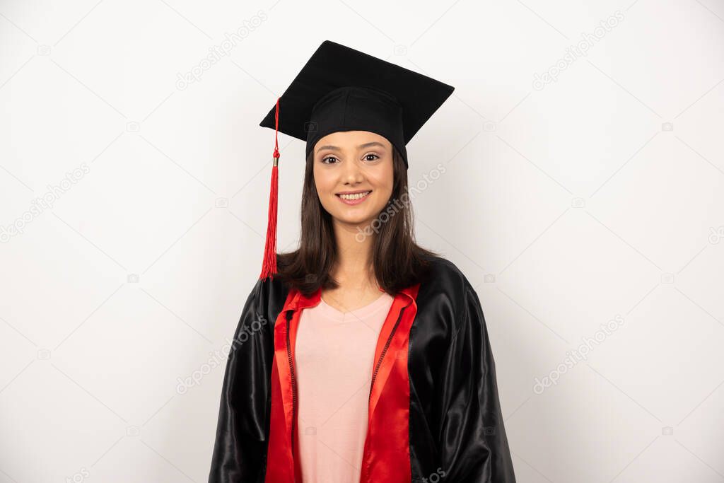 Happy graduate student in gown standing on white background. High quality photo
