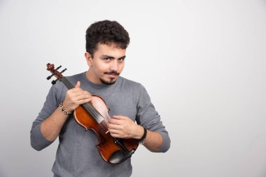 Kahverengi ahşap kemanını çalan bir müzisyen. Yüksek kalite fotoğraf