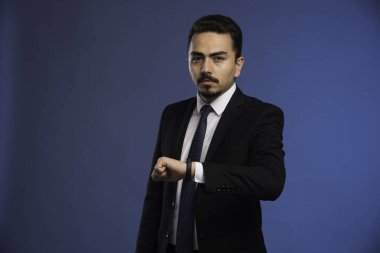 Siyah takım elbiseli, kravatlı bir iş adamı zamanını kontrol ediyor. Yüksek kalite fotoğraf