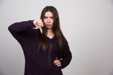 Kameraya baş parmağını gösteren genç bir kadın. Yüksek kalite fotoğraf