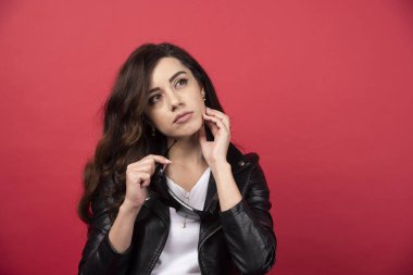 Kırmızı arka planda siyah gözlüklü genç bir kadın. Yüksek kalite fotoğraf