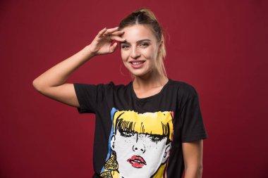 Kırmızı arka planda eli başının üstünde poz veren bir kadın. Yüksek kalite fotoğraf