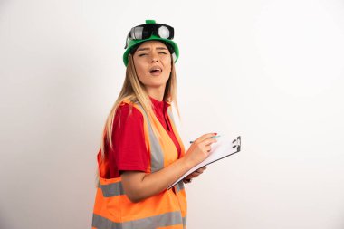 Beyaz arka planda çelik yelekli ve koruyucu kasklı bir kadın. Yüksek kalite fotoğraf