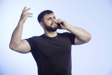 Siyah gömlekli sporcu adam telefonda agresif bir şekilde konuşuyor. Yüksek kalite fotoğraf