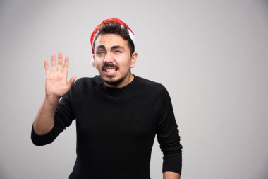 Noel Baba 'lı genç bir adam kırmızı şapkalı yüksek kaliteli fotoğraf sallıyor.