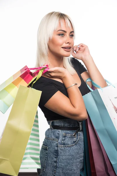 Jovem Feliz Segurando Sacos Compras Olhando Para Lado Fundo Branco — Fotografia de Stock