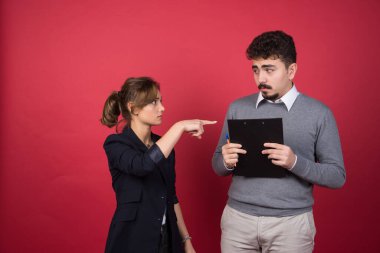 Ciddi bir kadın elinde pano olan bir adamı işaret ediyor. Yüksek kalite fotoğraf