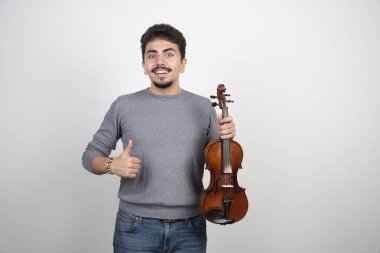 Müzisyen keman çalar, ilham verici ve pozitif görünür. Yüksek kalite fotoğraf