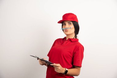 Dişi kurye, kalemini ağzında tutarken poz veriyor. Yüksek kalite fotoğraf