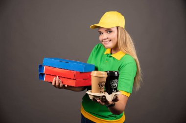 Teslimatçı kadın kahve ve karton pizza ikram ediyor. Yüksek kalite fotoğraf