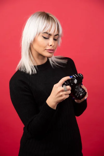 Giovane Donna Che Guarda Una Macchina Fotografica Uno Sfondo Rosso — Foto Stock