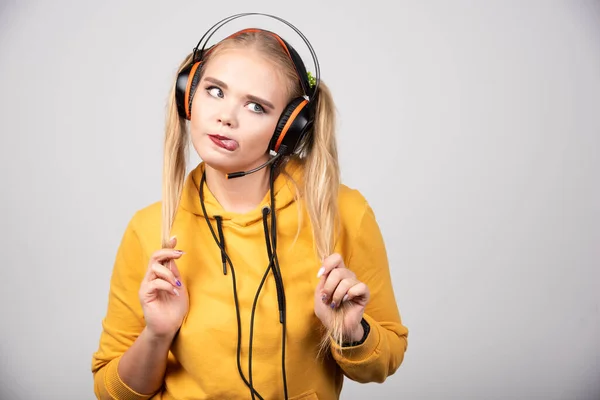 Foto Optimistisk Ung Kvinna Poserar Och Lyssnar Musik Med Hörlurar — Stockfoto