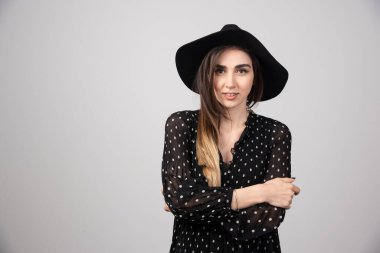 Siyah şapkalı, kollarını kavuşturmuş güzel bir genç kadın. Yüksek kalite fotoğraf