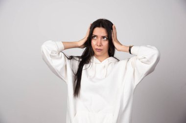 Düşünceli genç bir kadının portresi ayakta dikilip başka tarafa bakıyor. Yüksek kalite fotoğraf